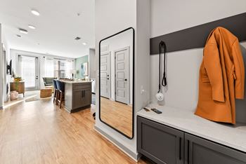 A modern kitchen with a wooden floor and a large mirror on the wall.